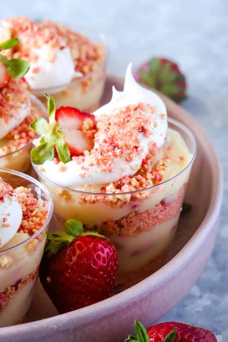 Strawberry pudding cups on pink plate and metal background. 