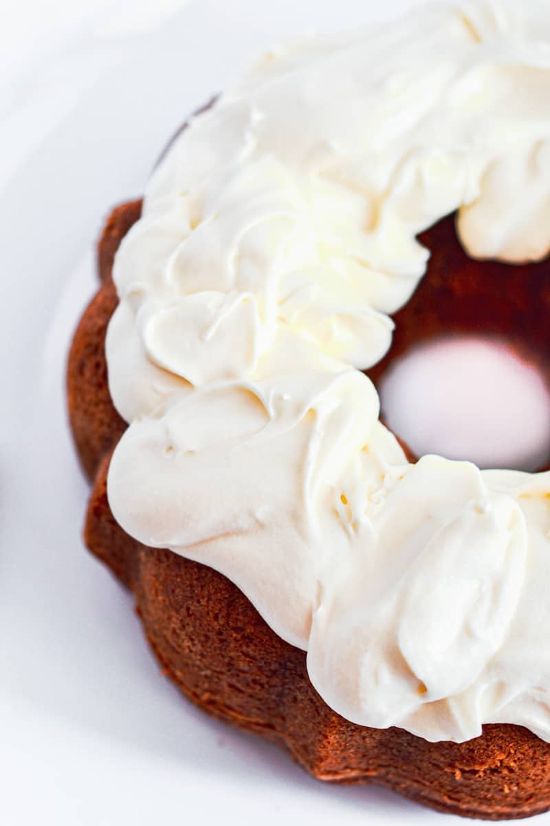 Topping the bundt cake with the cream cheese frosting. 