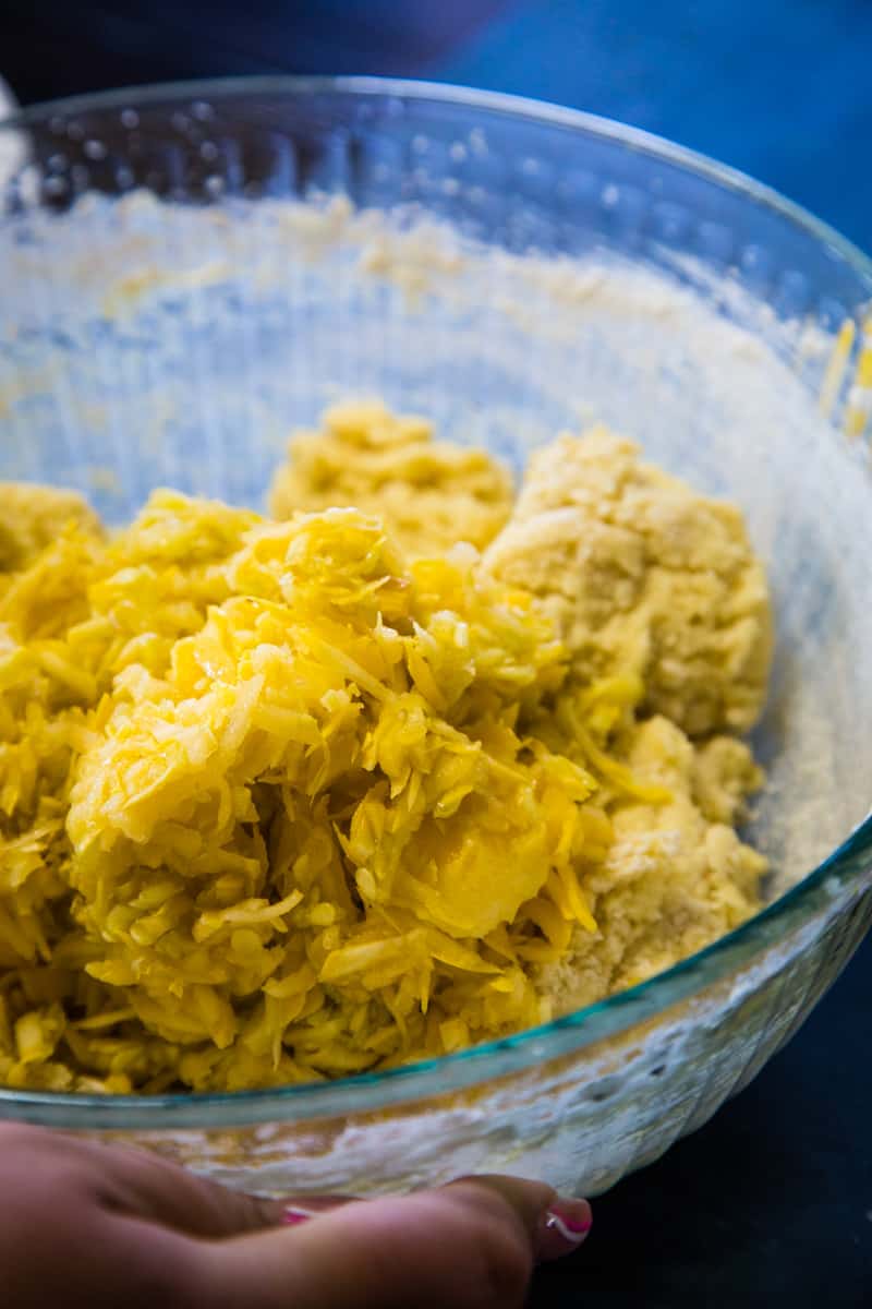 Adding the grated yellow squash to the bundt batter. 