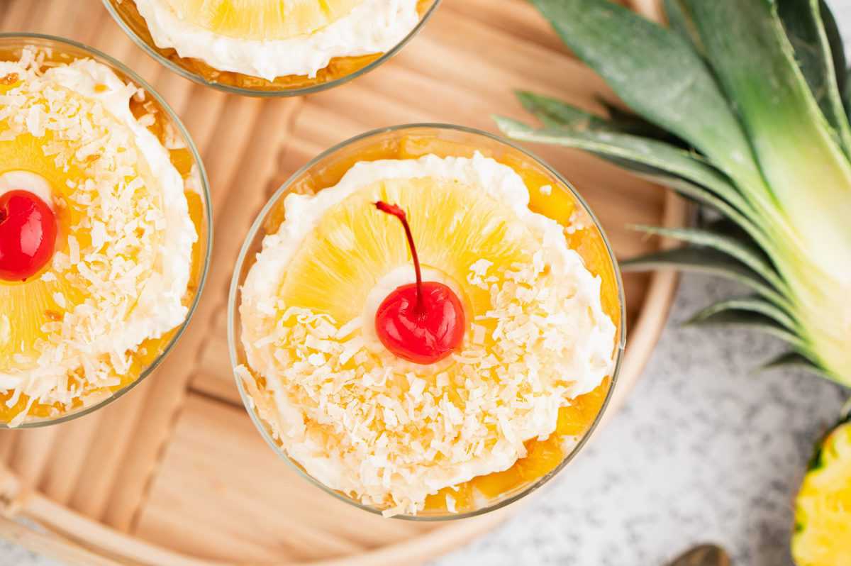 Overhead show of coconut and cherry topped pineapple trifles. 