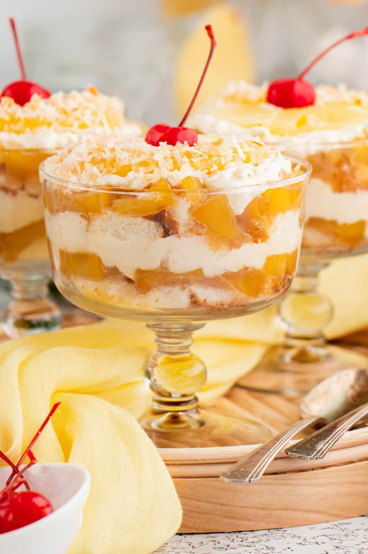 Photo of three wine glasses with pineapple upside down trifles. 