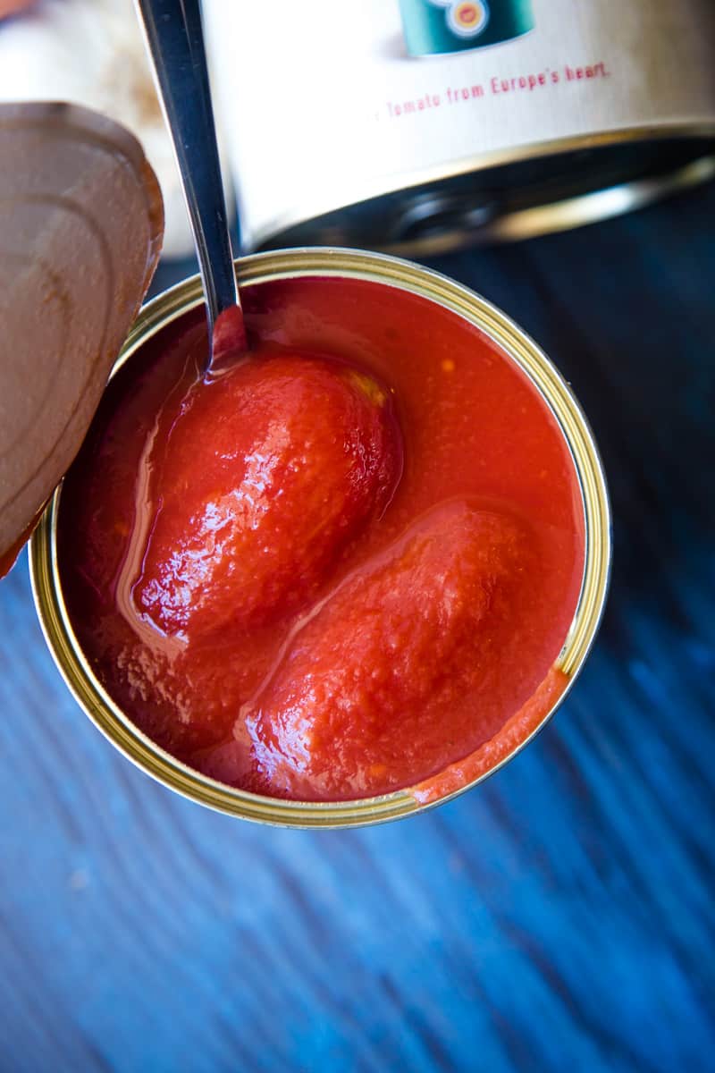 An opened can of san marazano tomatoes that are whole. 