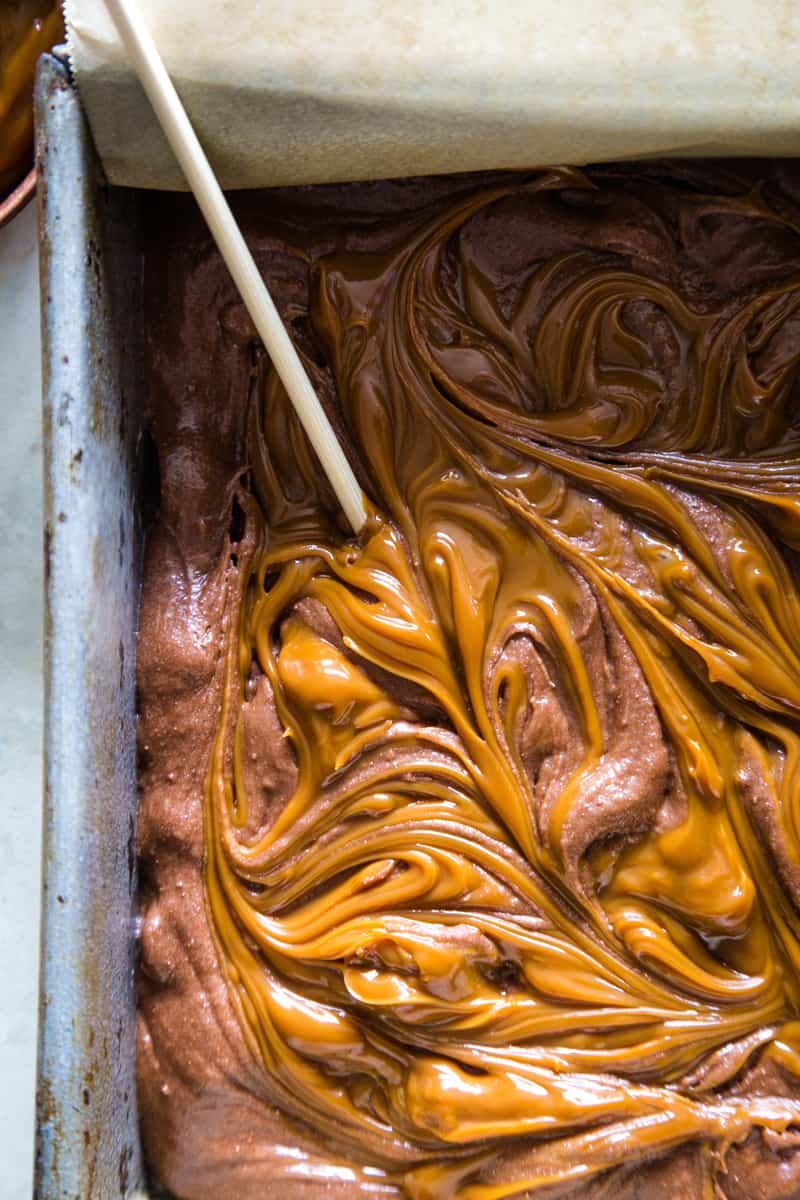 Swirling in the dulce de leche into the brownie batter with a toothpick. 