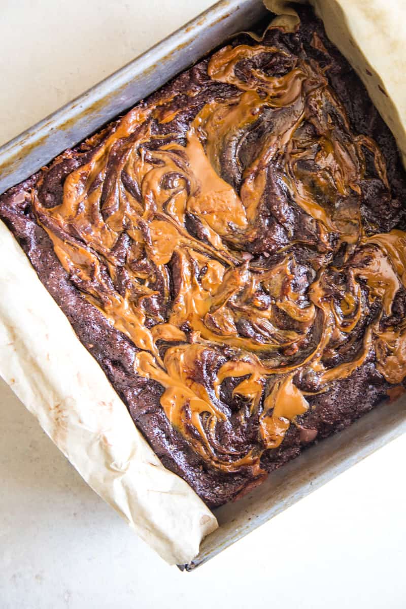 Overhead shot of the dulce de leche swirled brownies in the square pan. 