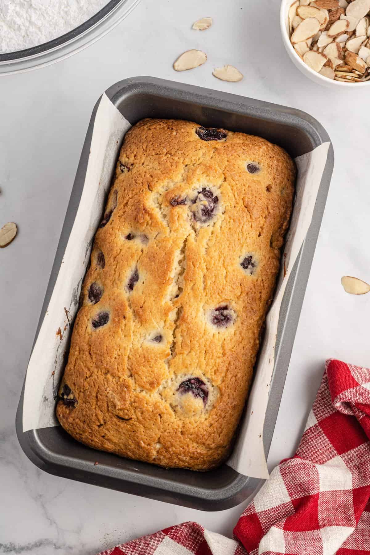 Loaf of cherry bread baked in pan.