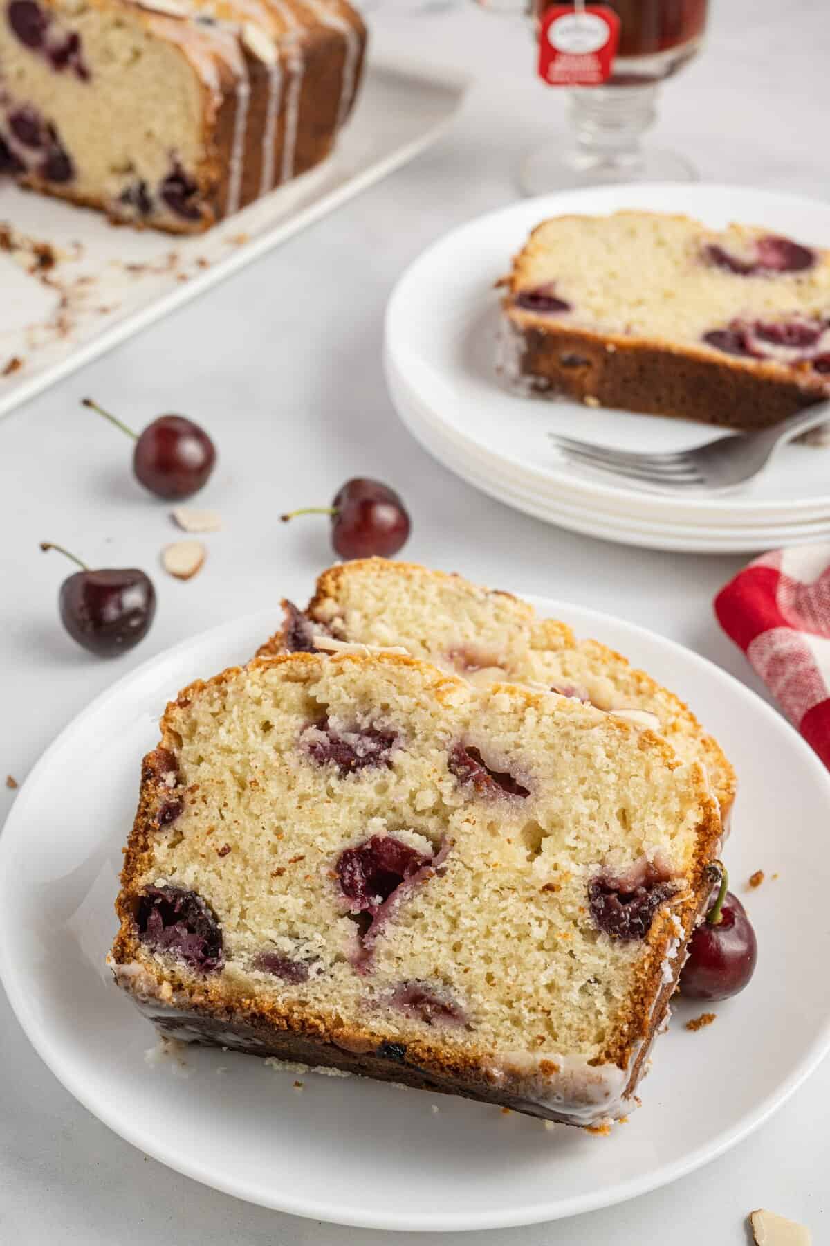 Sliced cherry bread on white plates and white background.