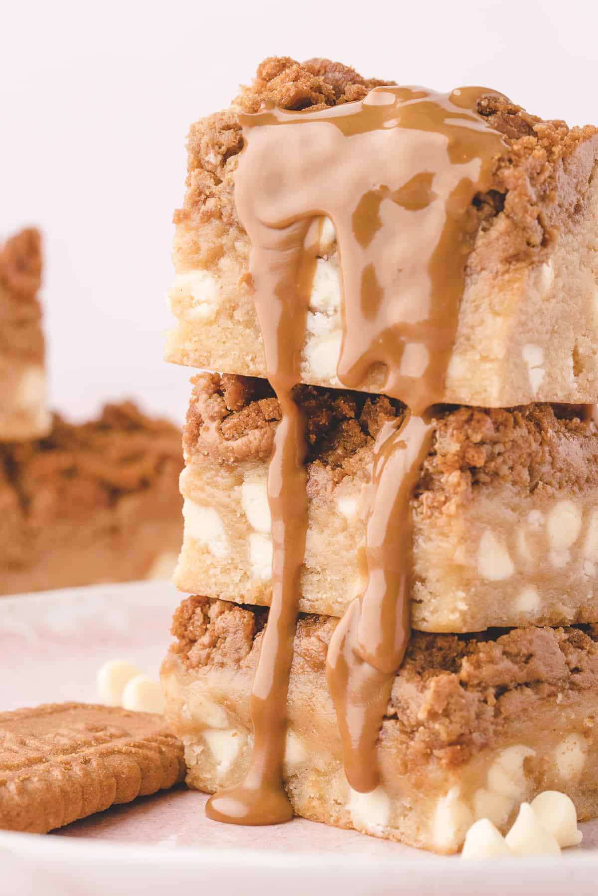 Three blondies stacked with melted biscoff dripping down the sides. 