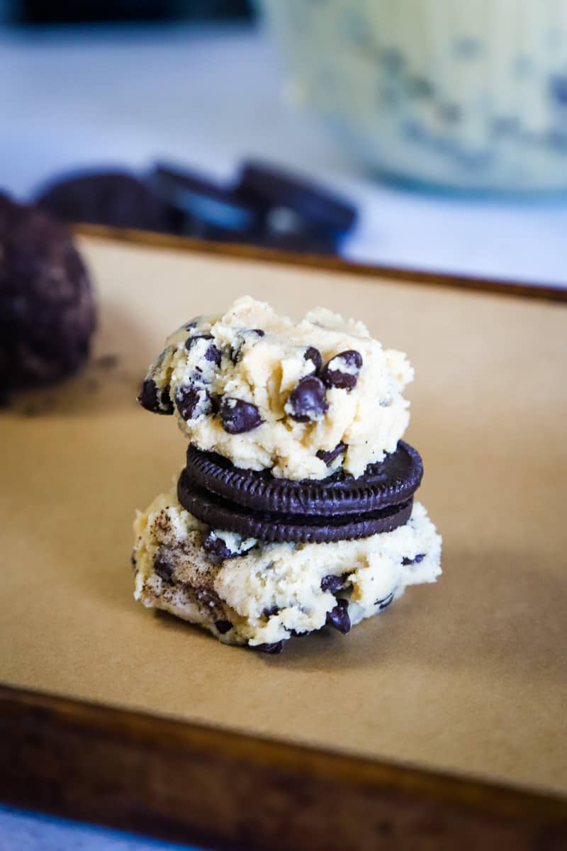 two scoops of cookie dough sandwiching an Oreo in the center. 