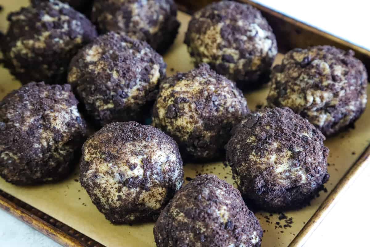 A tray of cookie dough balls that were rolled in Oreo cookie crumbs. 