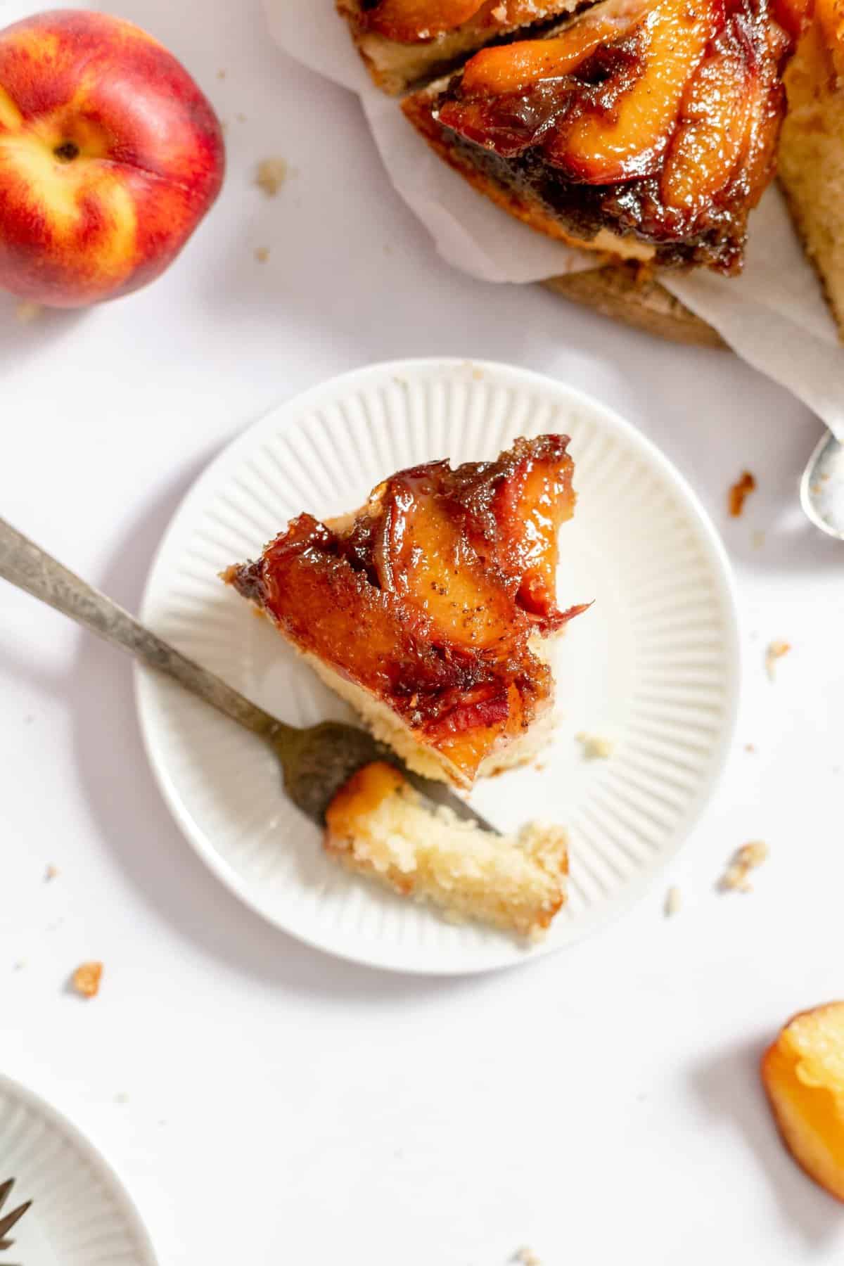 slice of cake on white plate with fork taking a bit out.