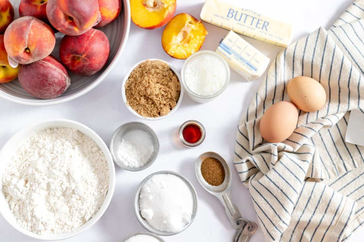 ingredients laid out on white background to make the peach upside down cake.