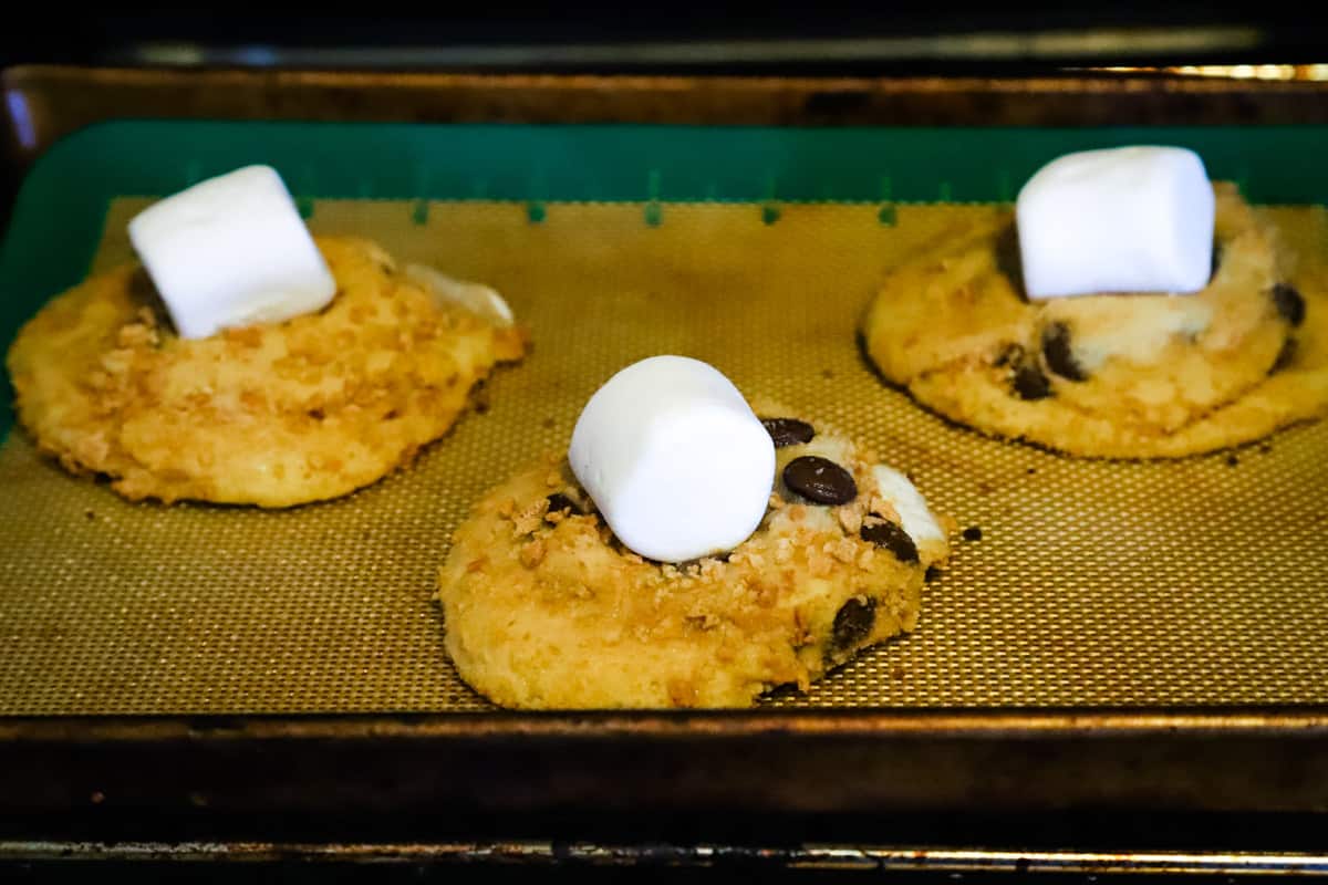 Cookies being baked with a marshmallow on top. 