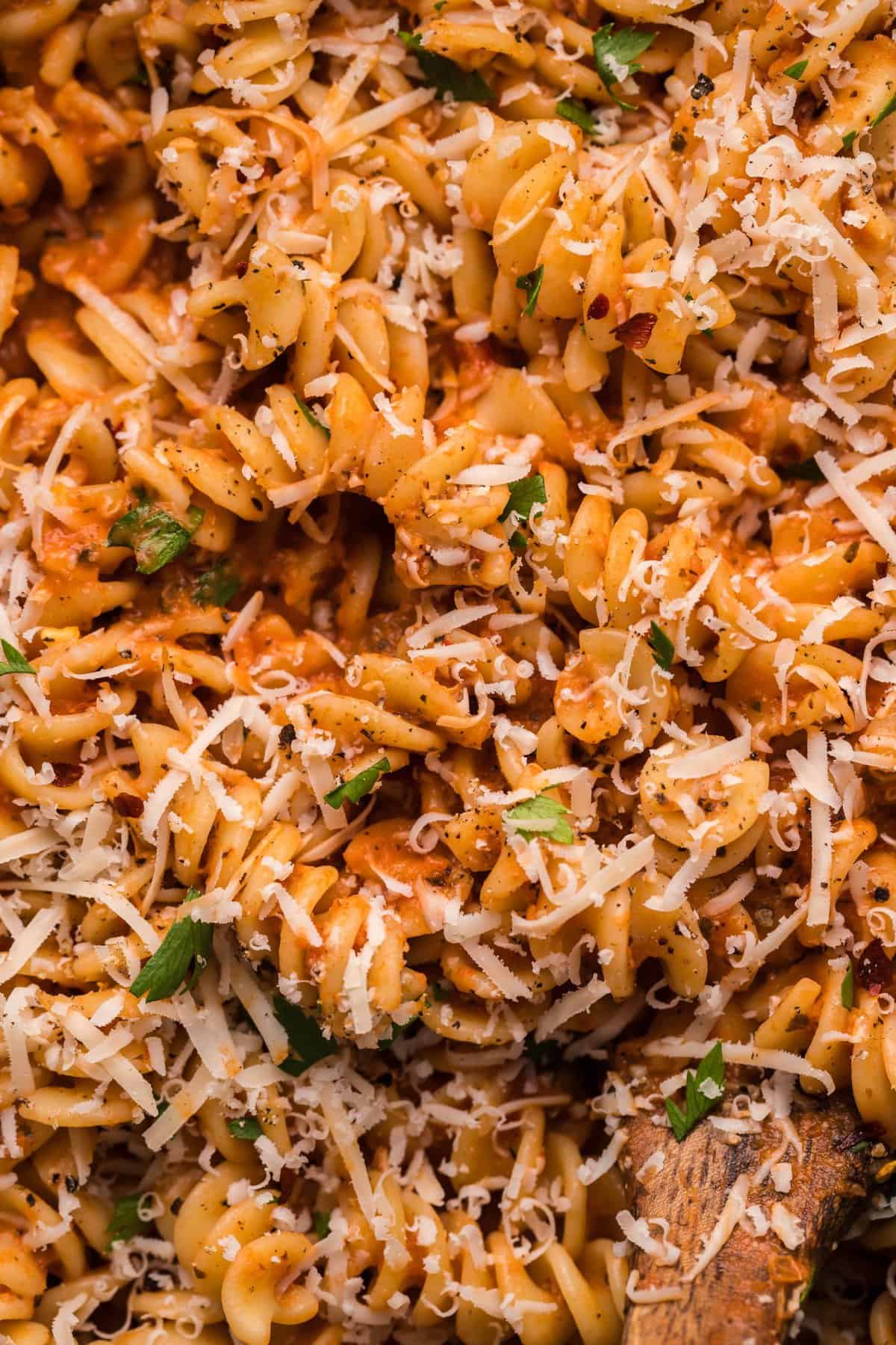 Up close photo of the spicy fusilli pasta garnished with shredded parmesan cheese.