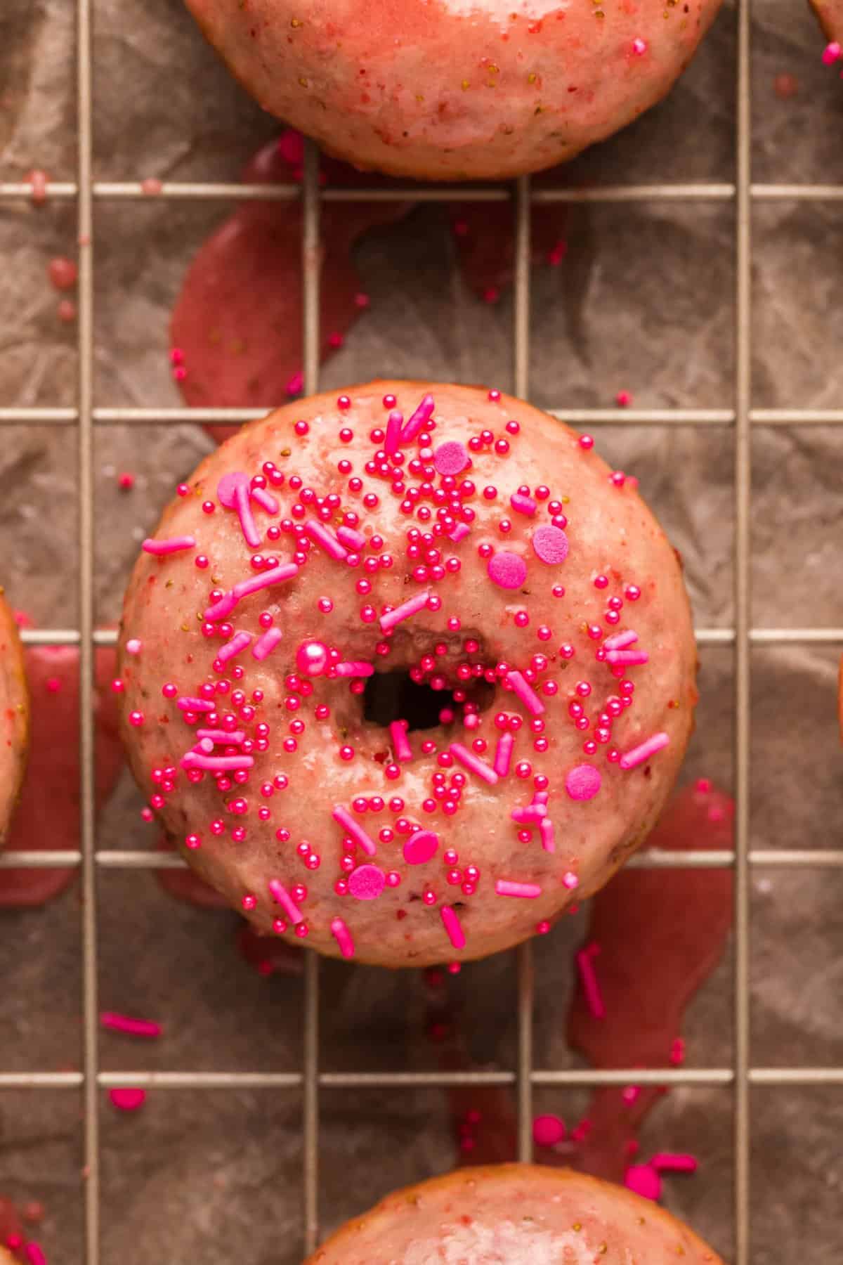 Up close photo of one donut that has been glazed and sprinkles.