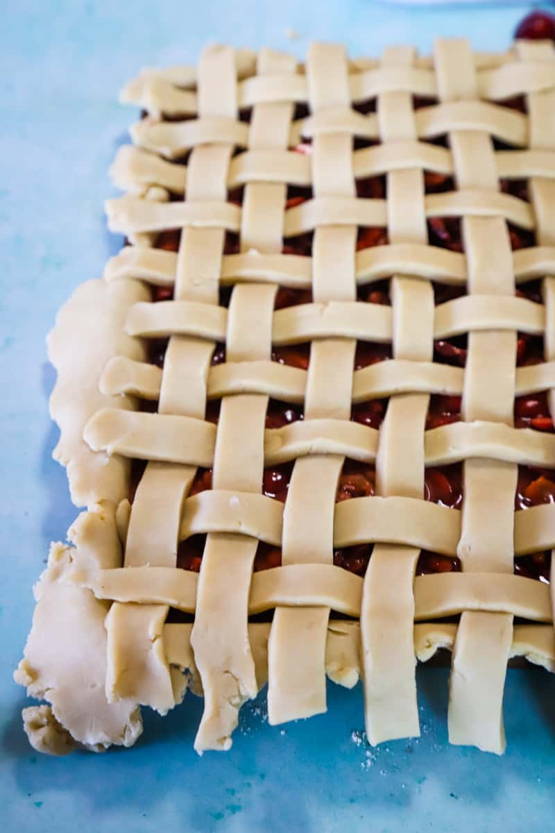 Finished unbaked lattice crust weave on cherry pie filling. 