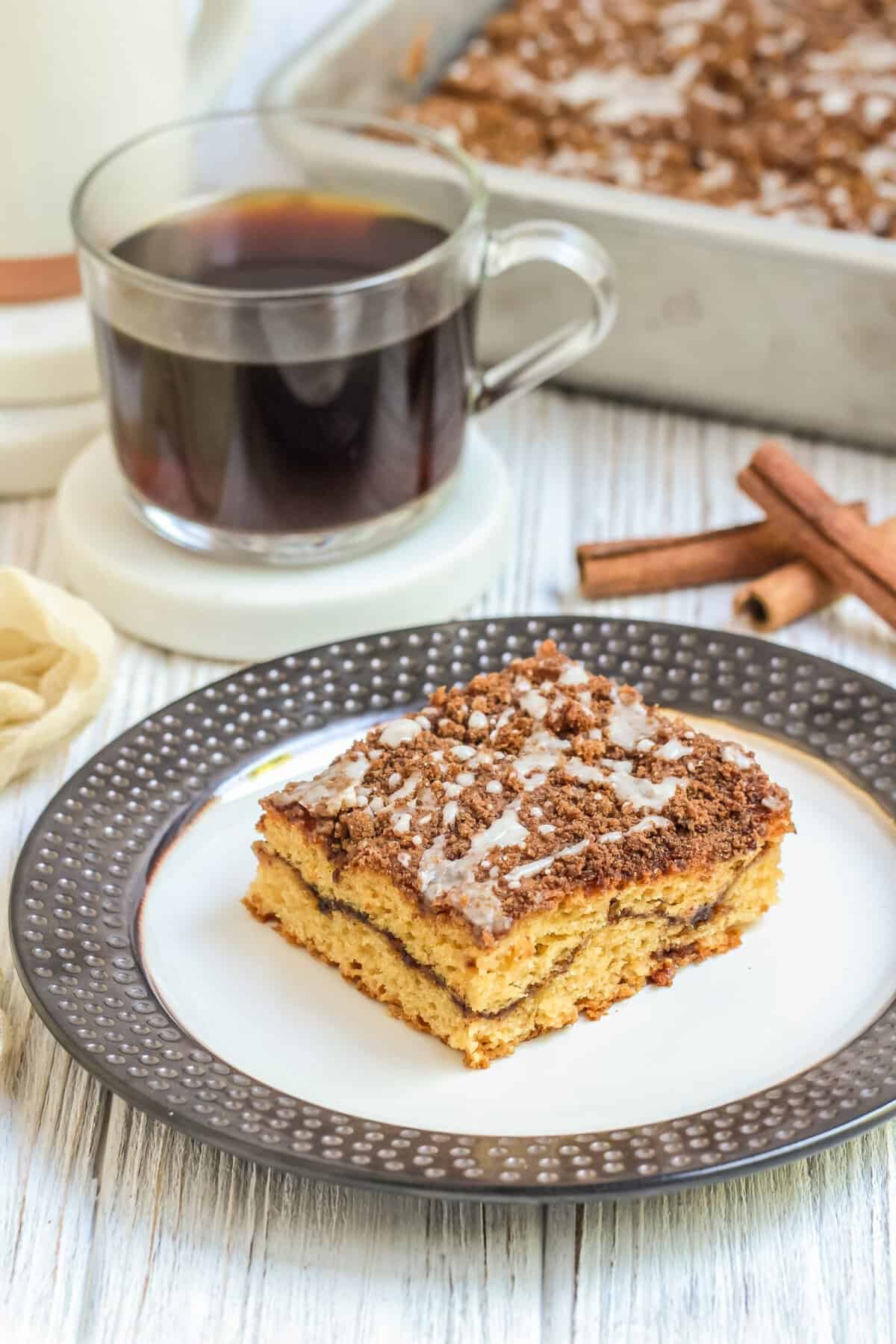 white plate with silver rim and square slice of coffee cake in the center. 