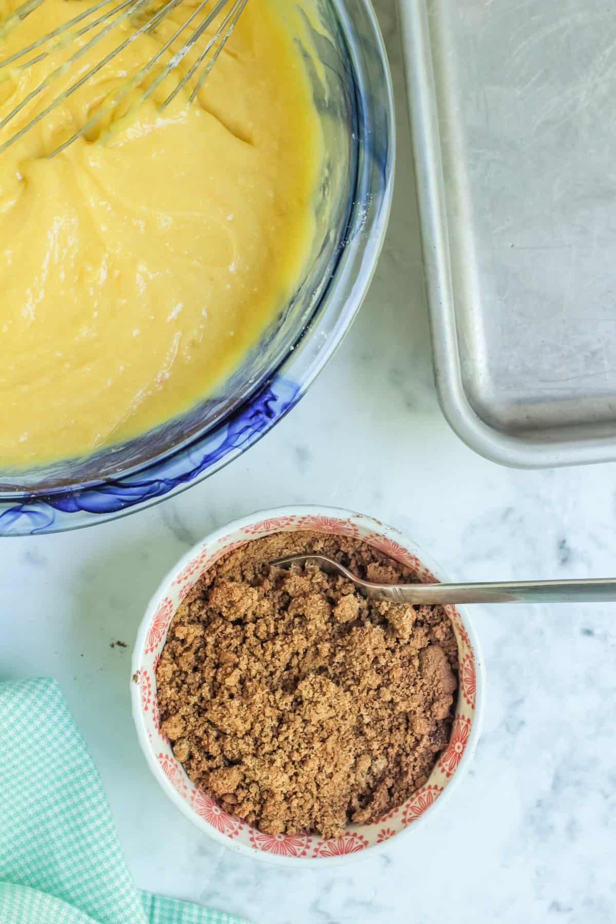 small bowl with the brown sugar crumb mixture with cake mix batter in the corner. 