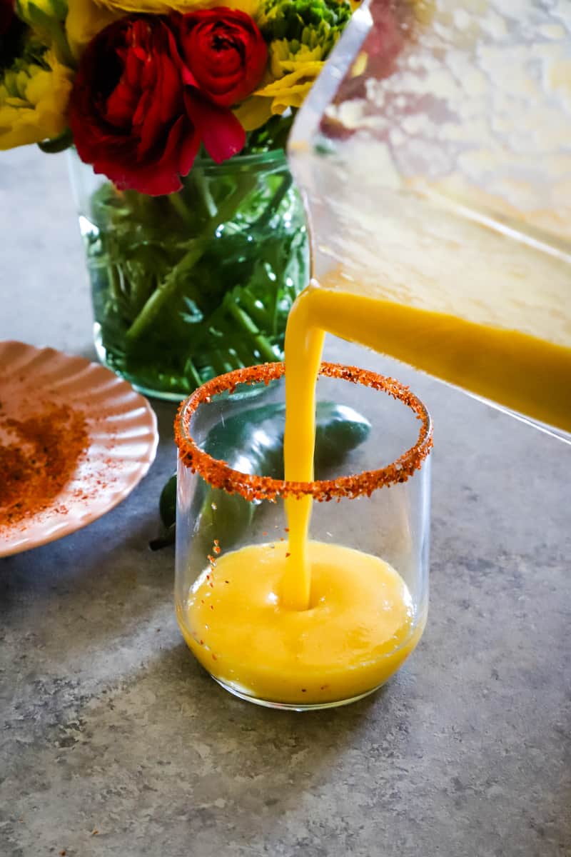 Pouring the mango margarita into the tajin rimmed glass. 