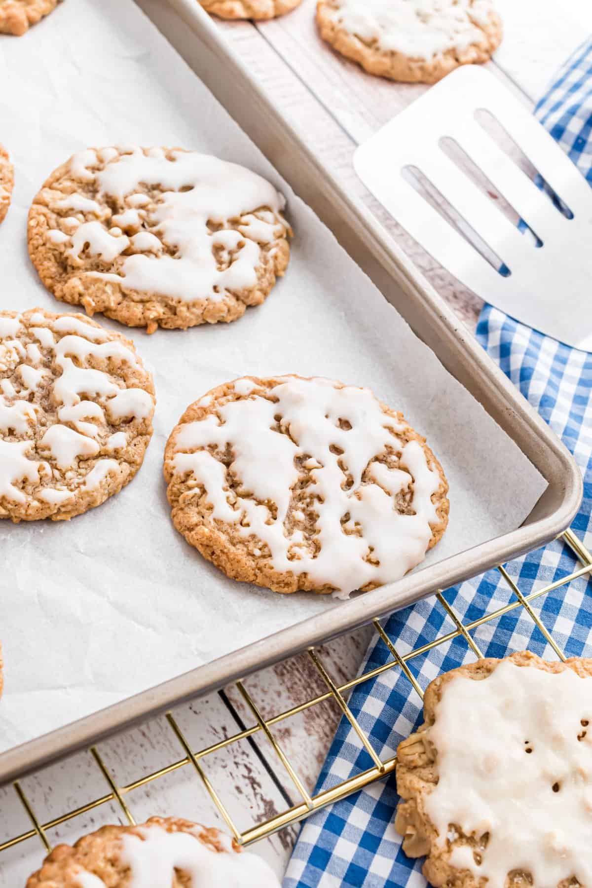 Cookies on a parchment lined cookie sheet with a spatula in the corner. 