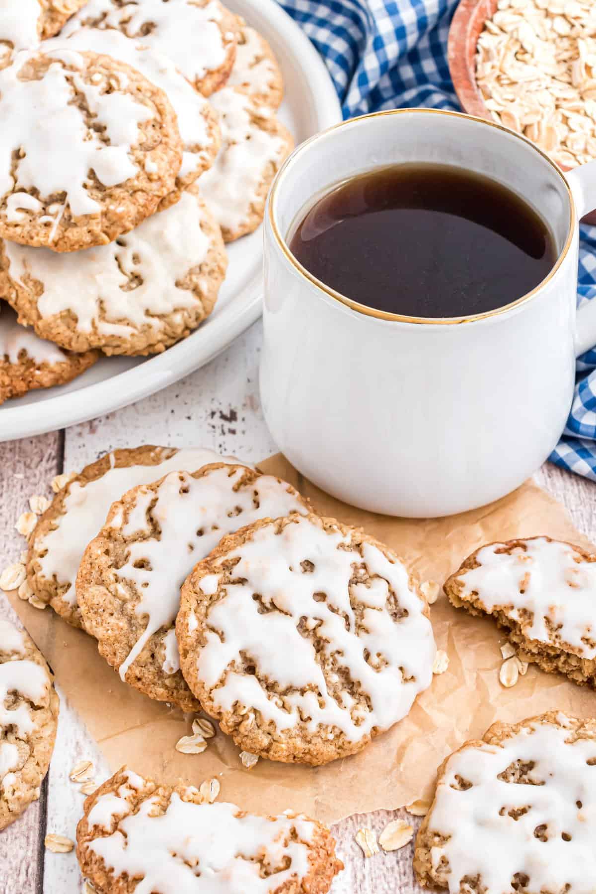 Cookies scattered on brown parchment paper with a white cup of coffee in the upper right corner. 