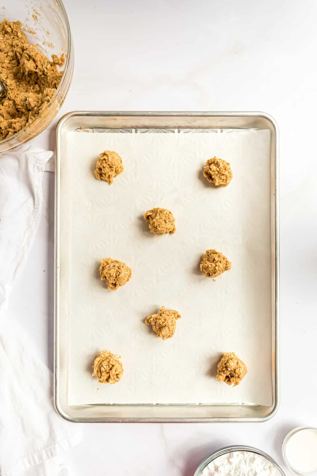 Rolled out oatmeal cookie dough on a parchment lined cookie sheet. 