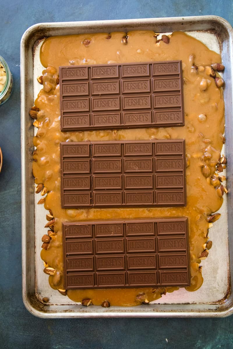 Putting the chocolate bars onto the hot toffee to melt. 