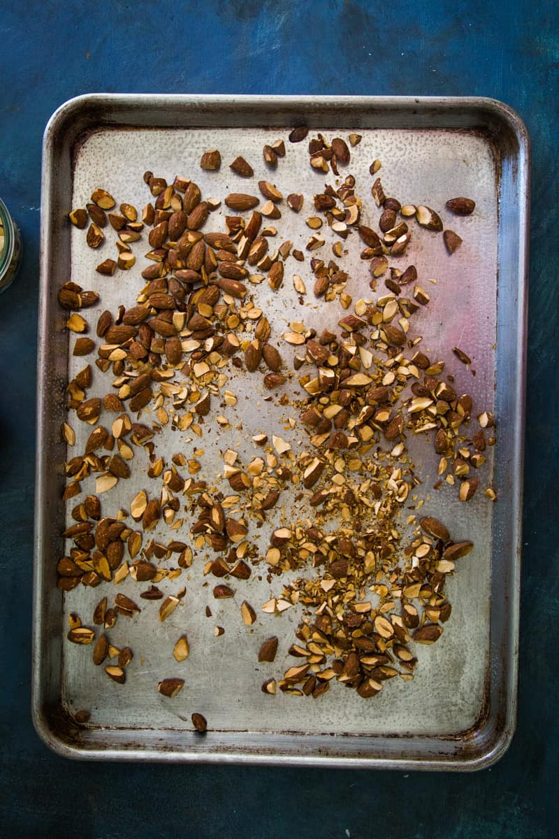 Placing the chopped nuts on the greased cookie sheet.