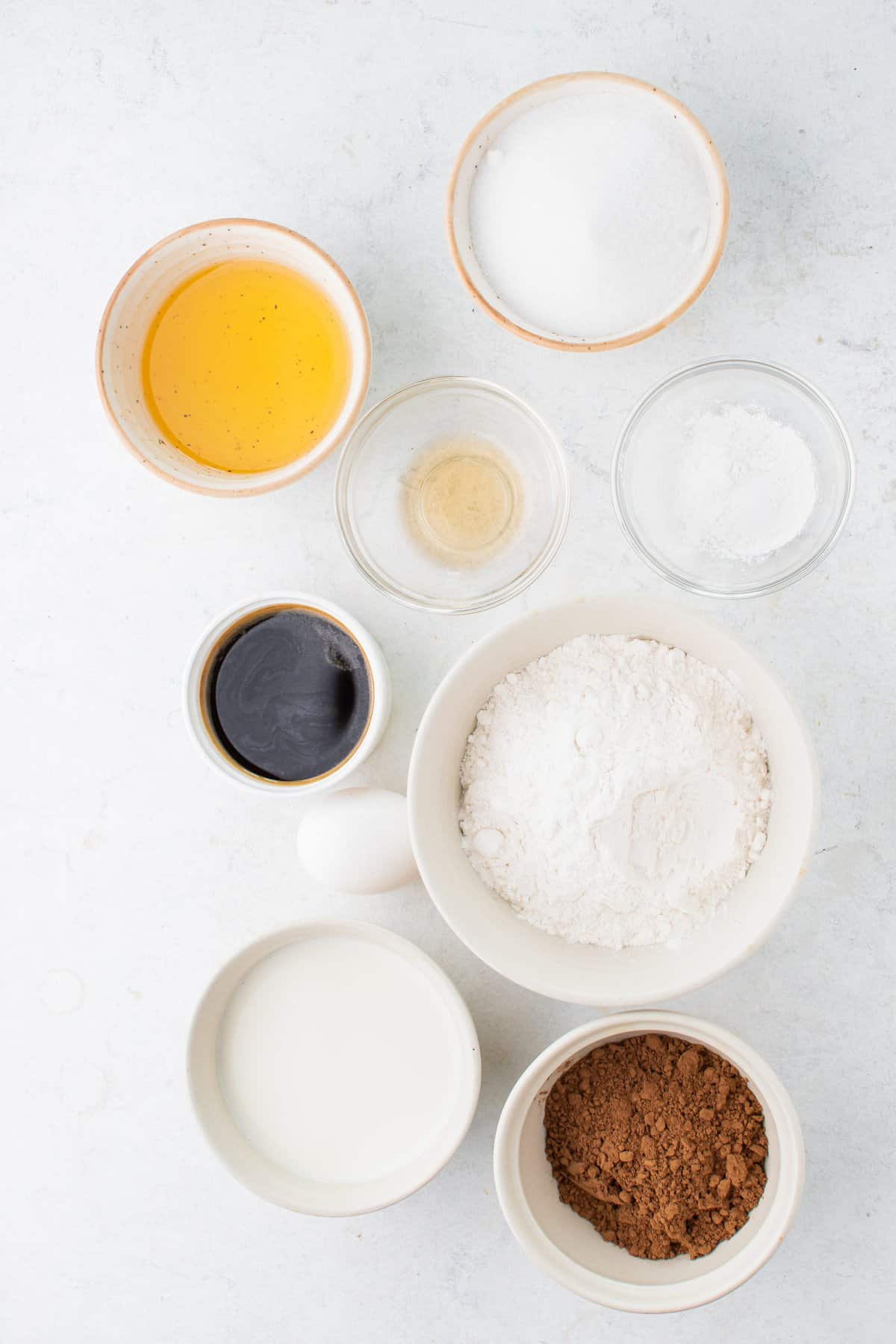 Ingredients to make the chocolate cupcakes in small white bowls. 