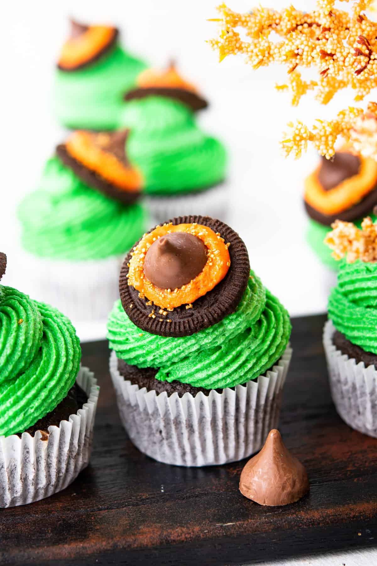 Up close photo of the cupcake with green frosting and cookie chocolate witch hat. 