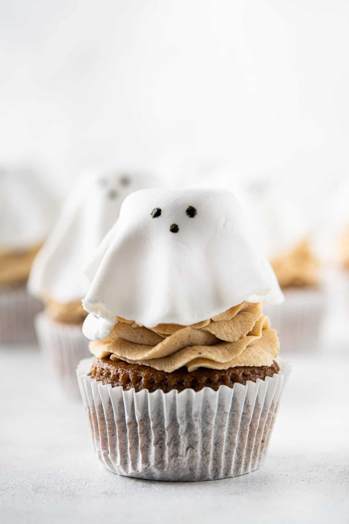 Cupcake with fondant shaped as a ghost on a chocolate cupcake. 