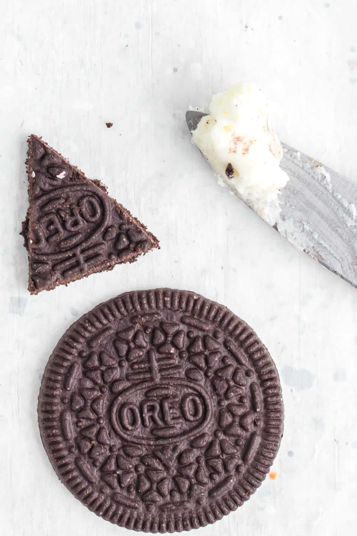 oreo cookie cut into a triangle and a whole round cookie on white background. 