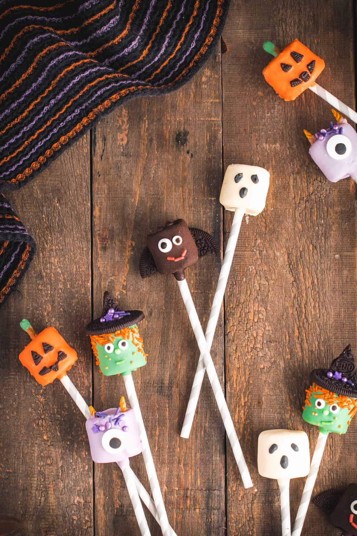 Halloween decorated marshmallow pops on a wooden background. 