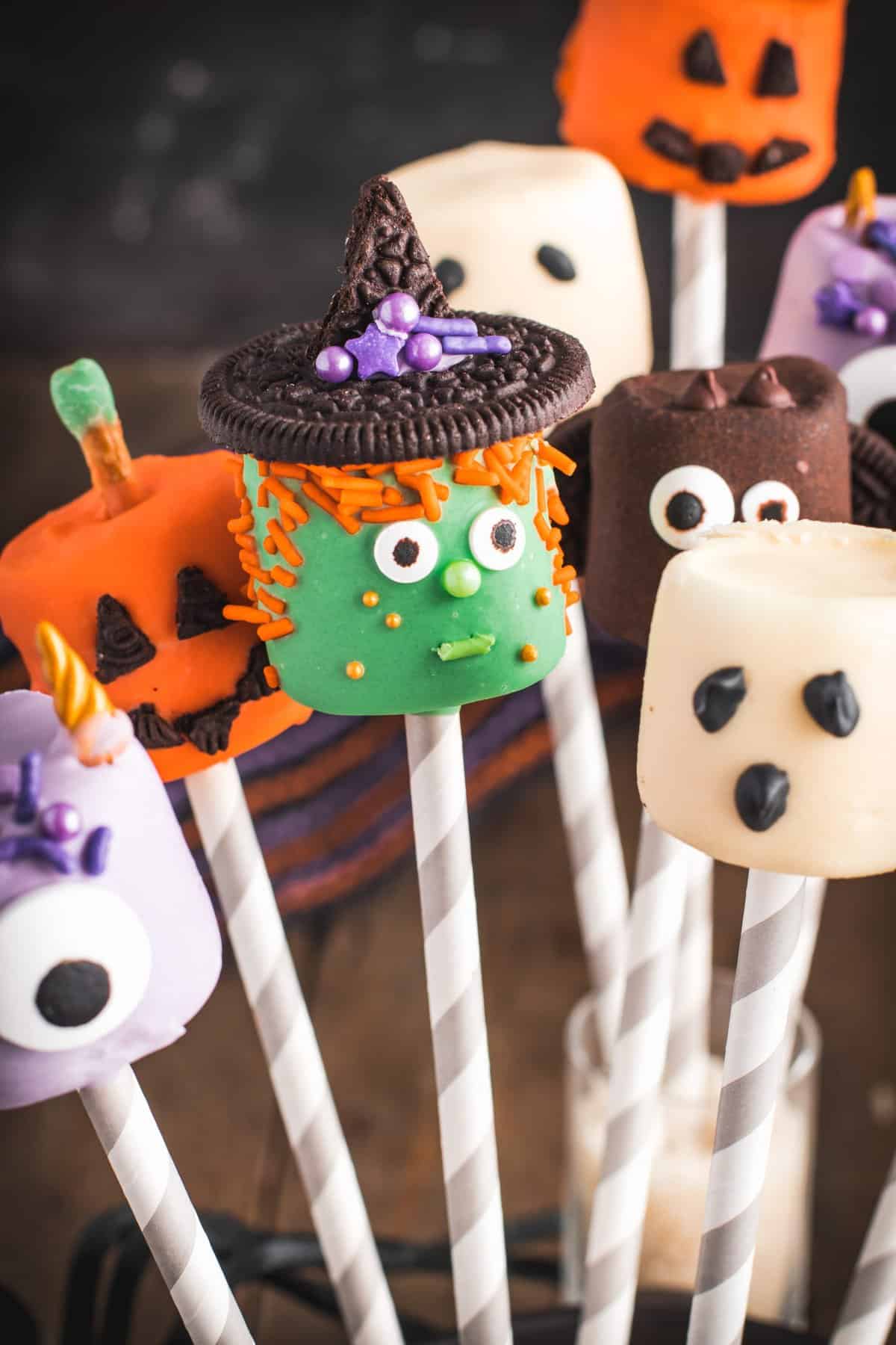 Halloween decorated marshmallow pops with the focus on the green which pop. 