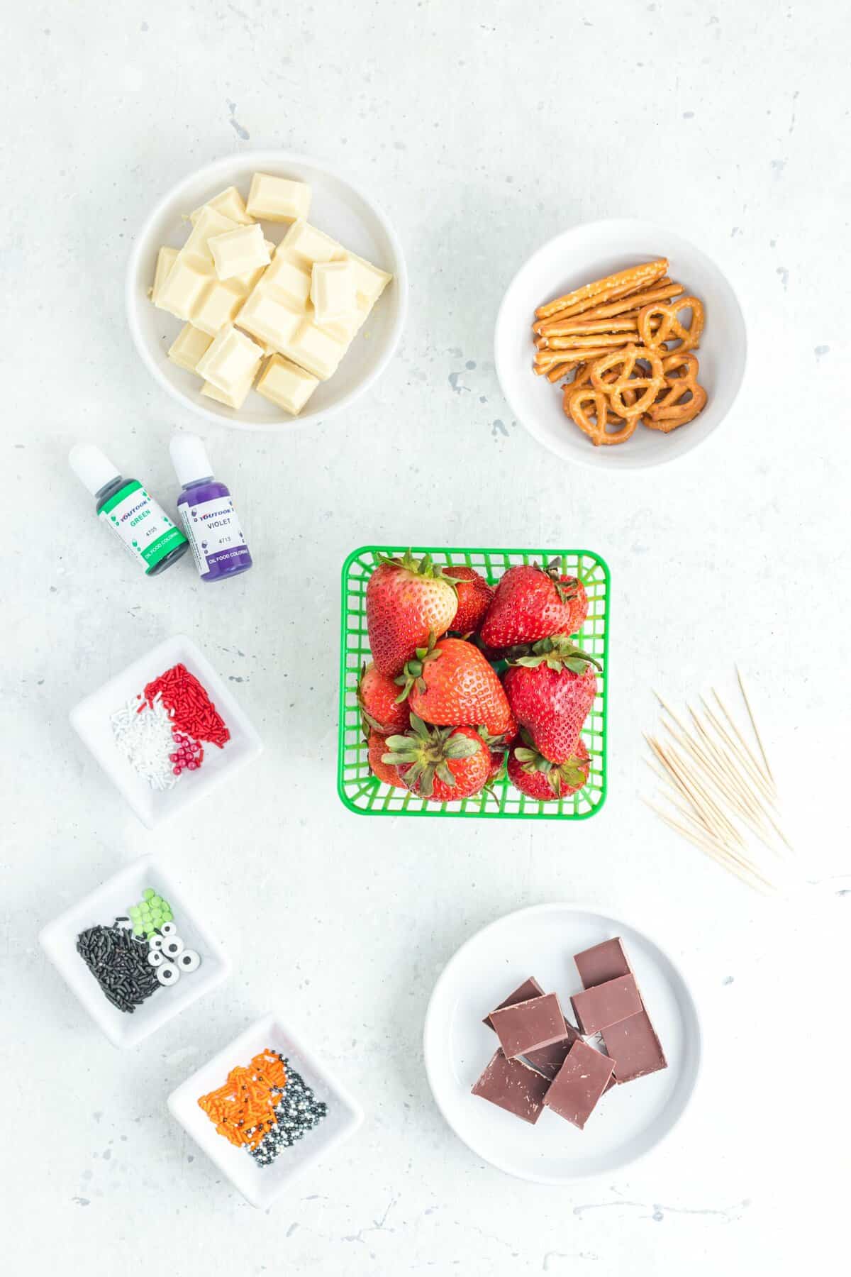 Ingredients to make the halloween chocolate dipped strawberries on a white background. 