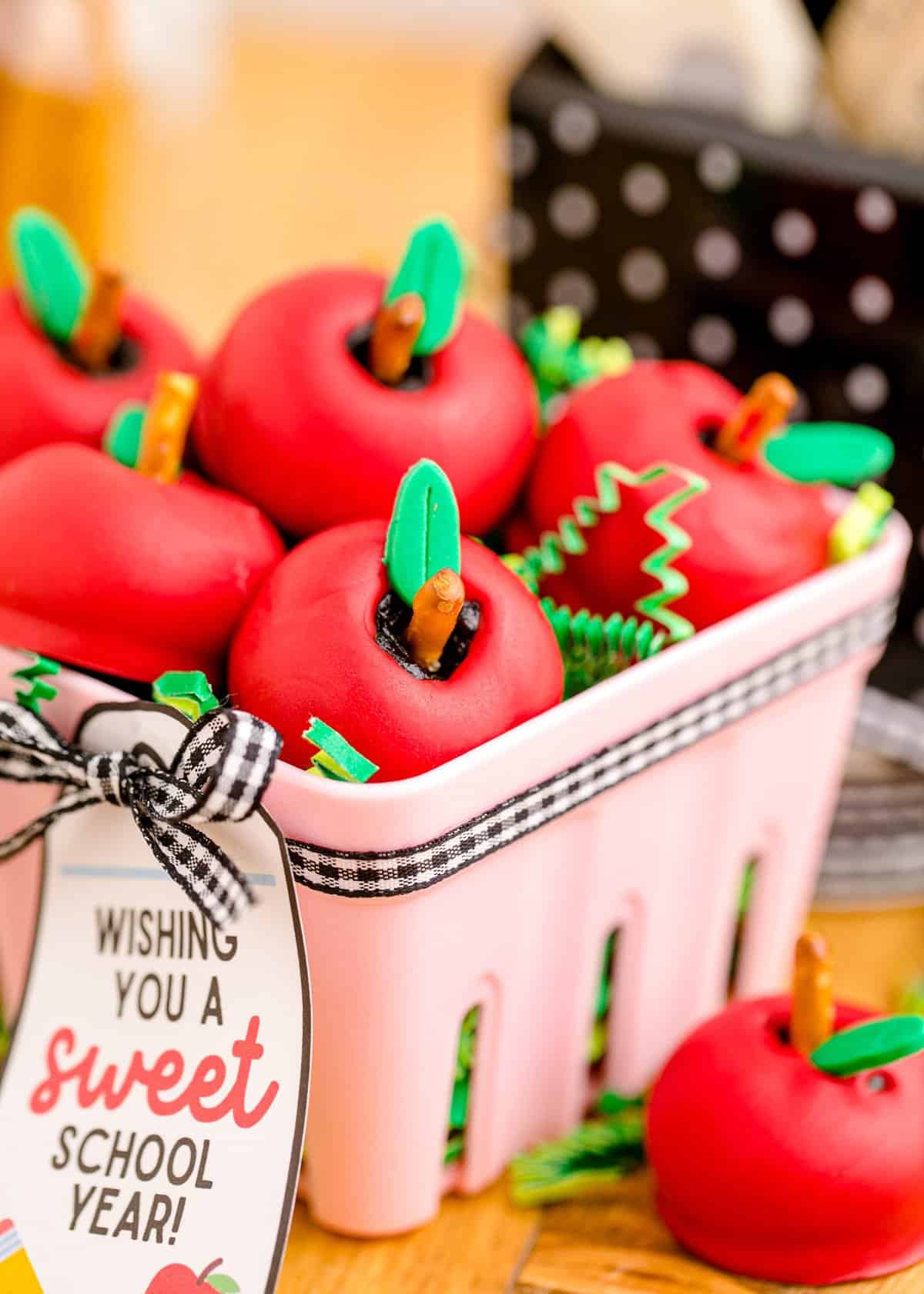 Apple oreo balls stacked in a cute pink fruit basket.