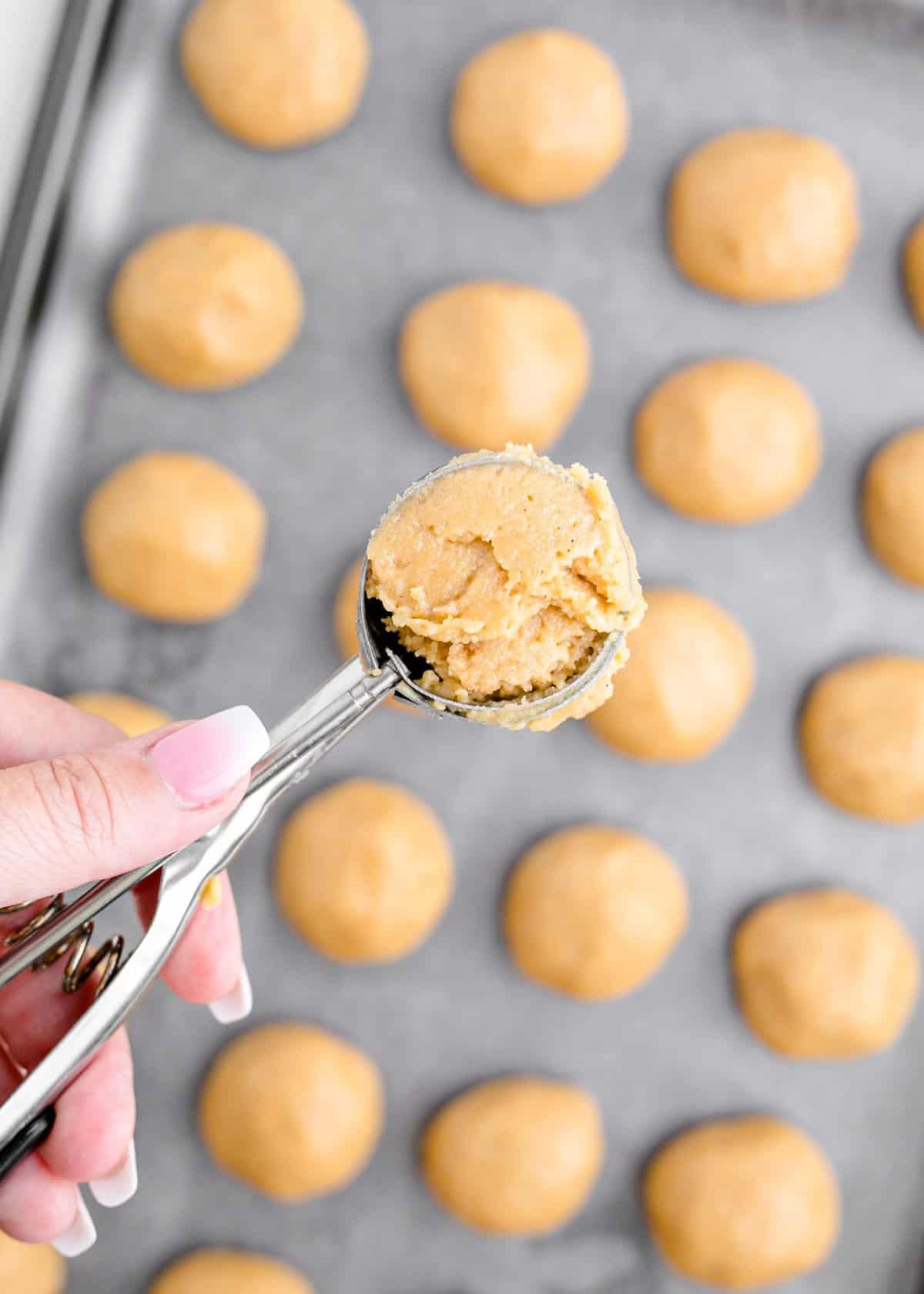 Taking a cookie scoop of the golden oreo truffle dough before rolling into balls. 