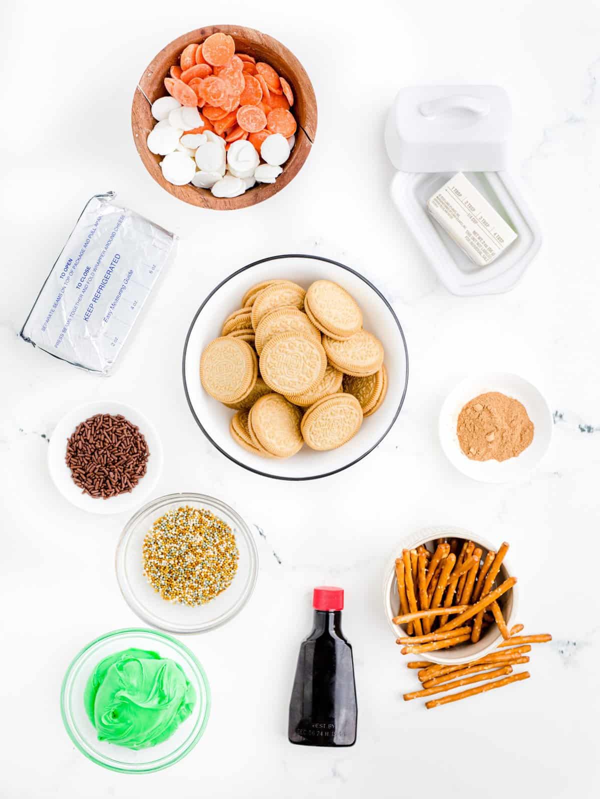 All of the ingredients to make the oreo pumpkin truffles on a white background. 