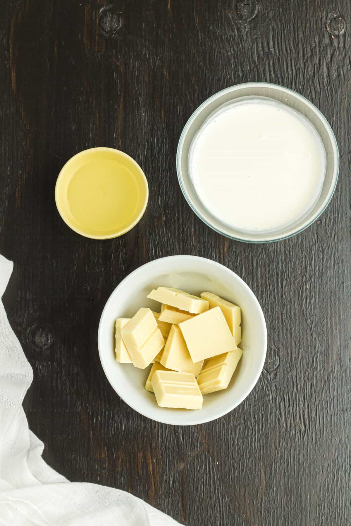 A bowl of white chocolate, cream, and ingredients to make the ganache filling.