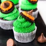 Square image of the witch's hat cupcakes on black plate.