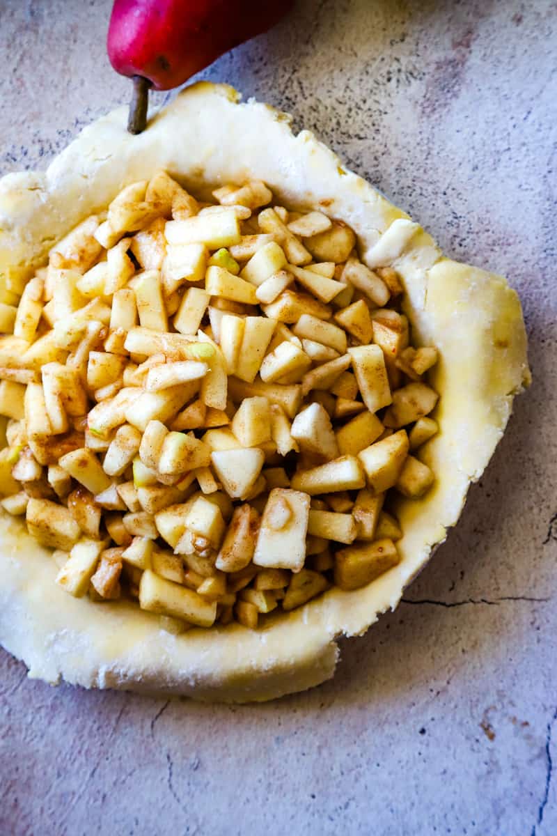 Filling the bottom crust with the apple pear pie filling.