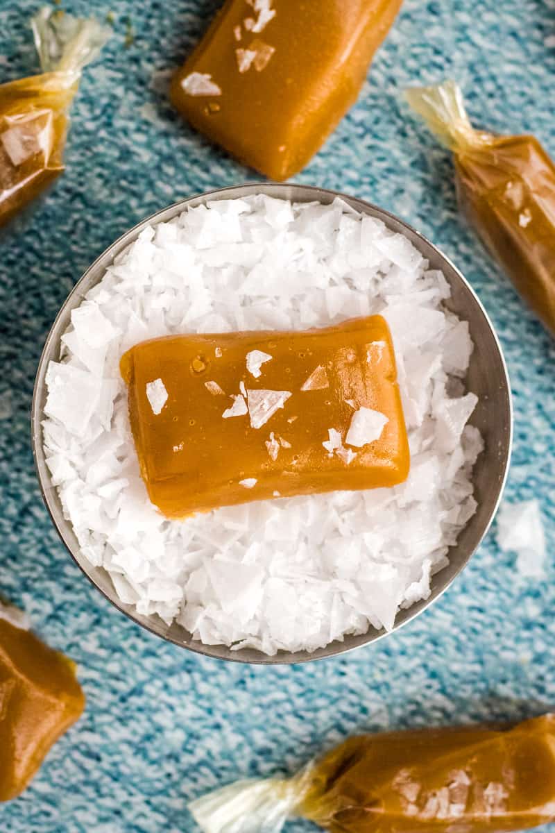Bowl of flaked sea salt with a brown sugar caramel in the center. 