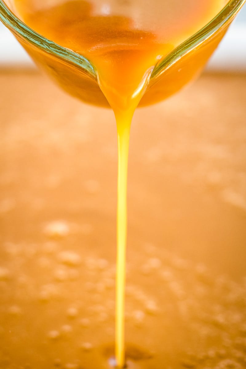 Pouring the hot caramel into the prepared baking sheet.