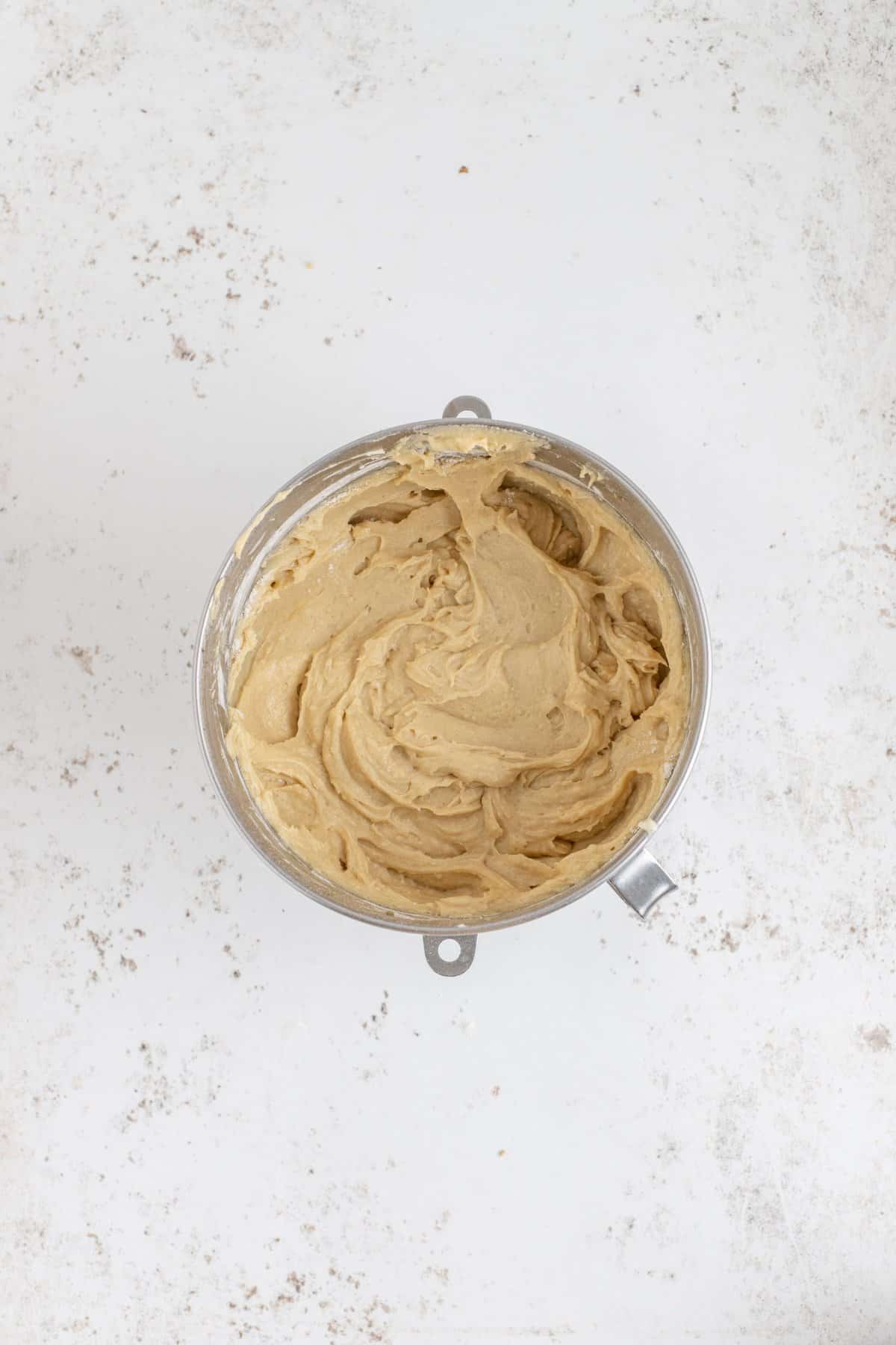 The finished maple cake batter in metal bowl of the stand mixer. 
