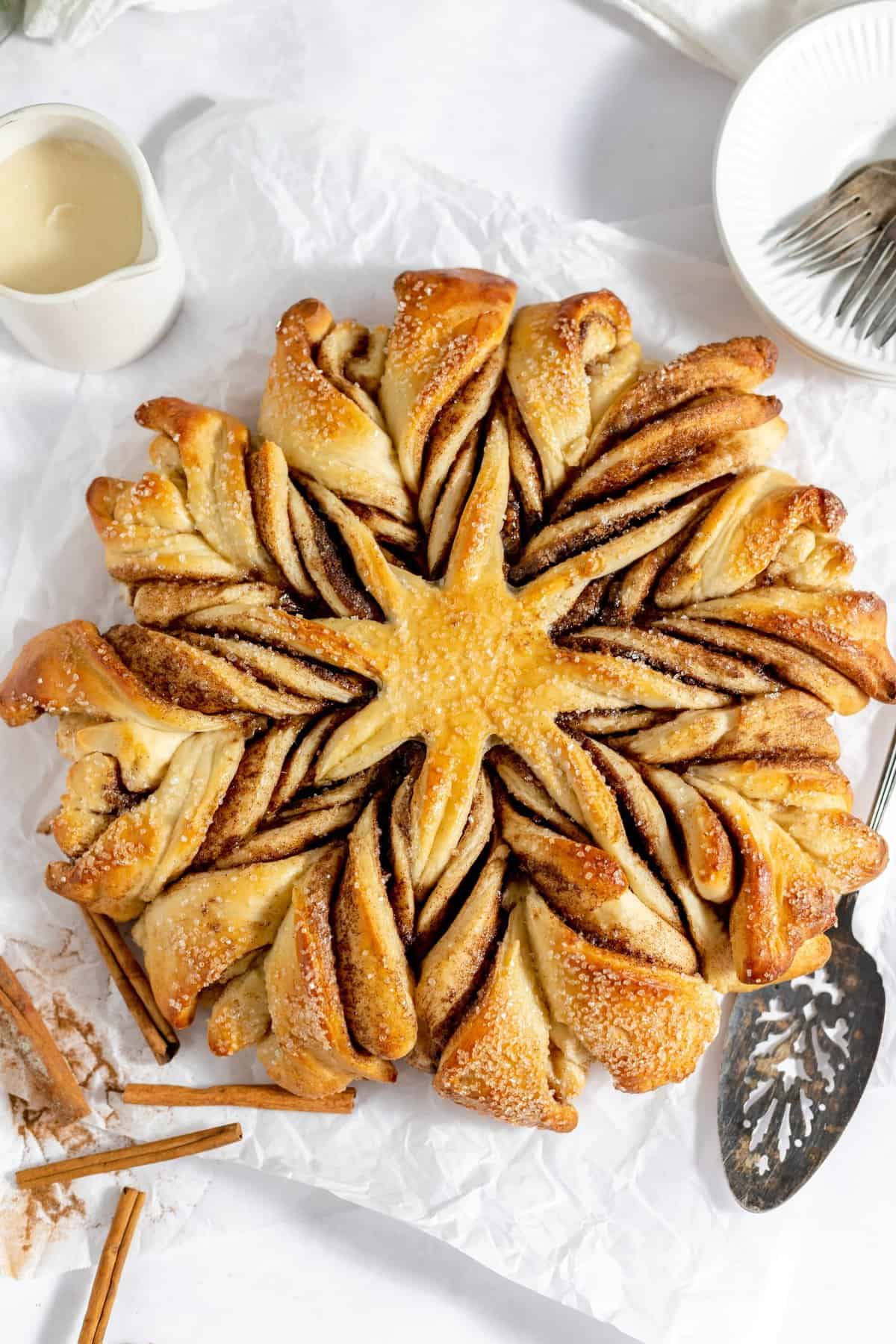 Overhead shot of the cinnamon star bread on white background with spatula to the side. 