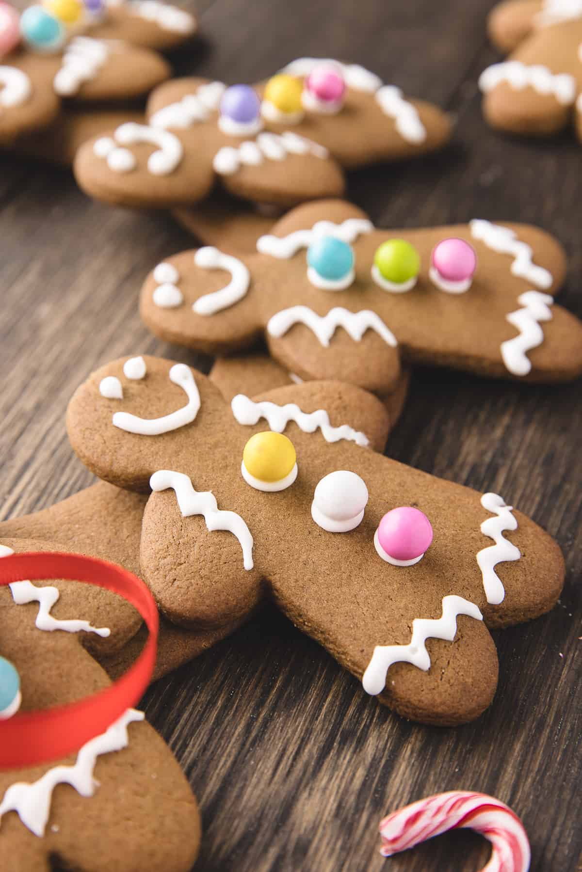 Gingerbread men glued to edible wreath on wood background. 