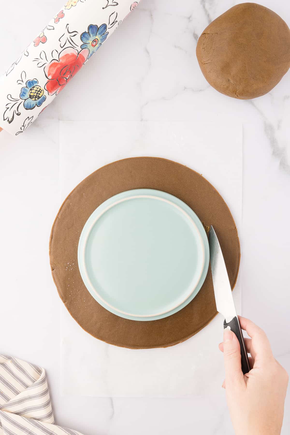 Taking a smaller plate and cutting around it to create a wreath shape.