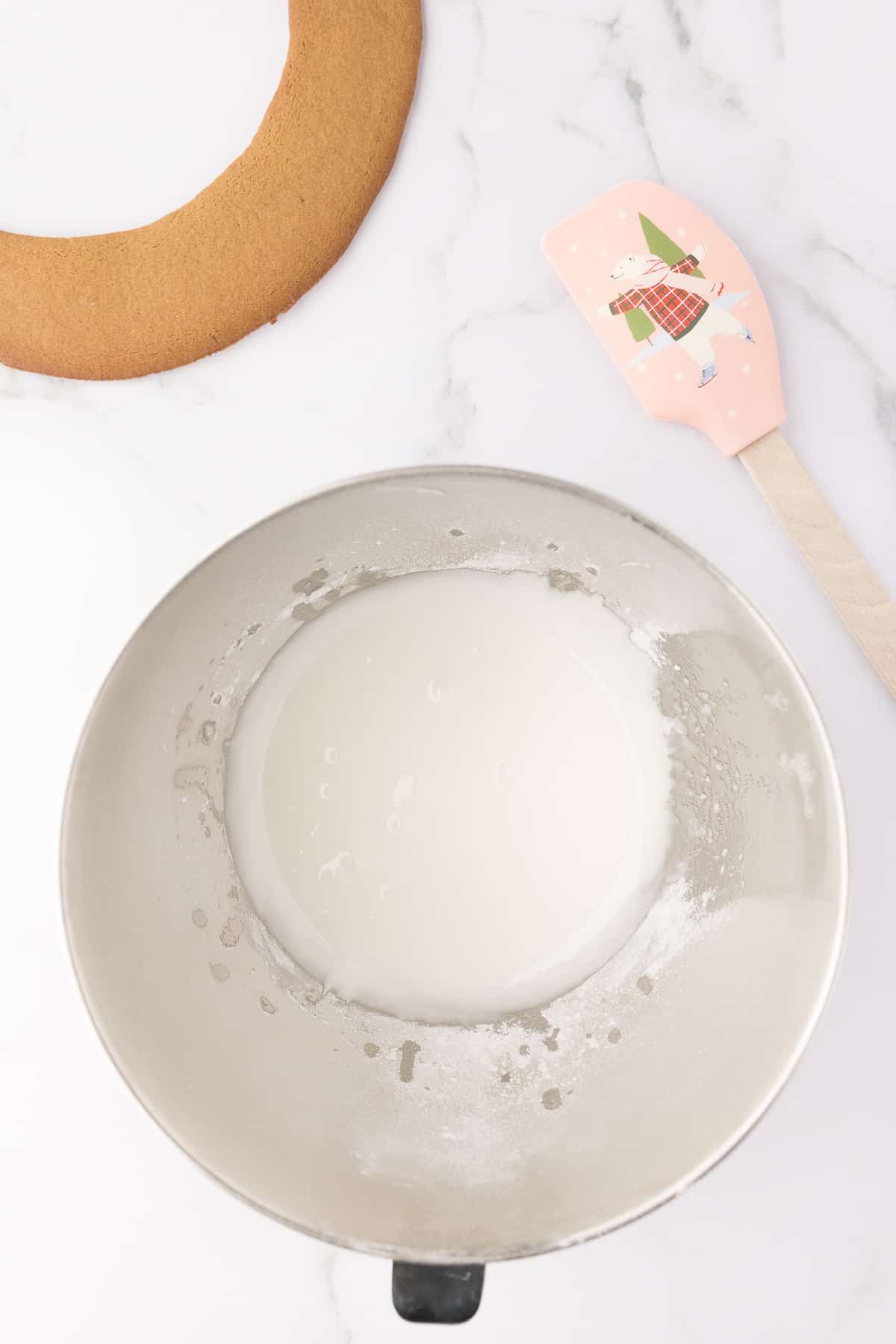 Making the royal icing in a large metal bowl on white background. 