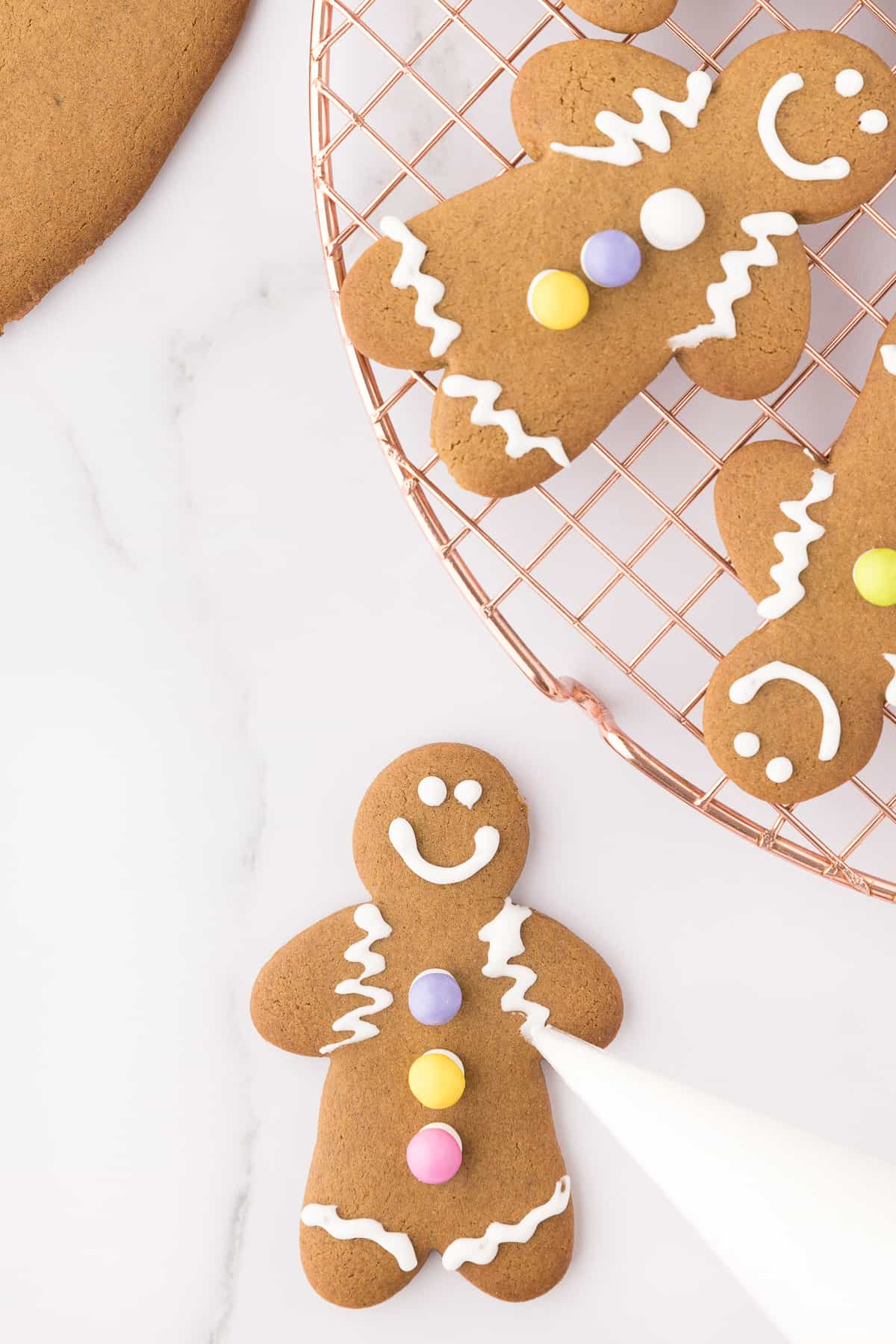 Decorating the gingerbread men with the royal icing on white background. 