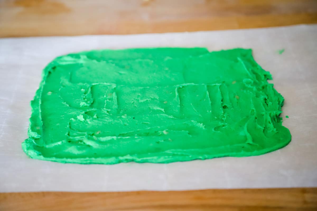 Spreading out the green batter onto a sheet of parchment paper. 