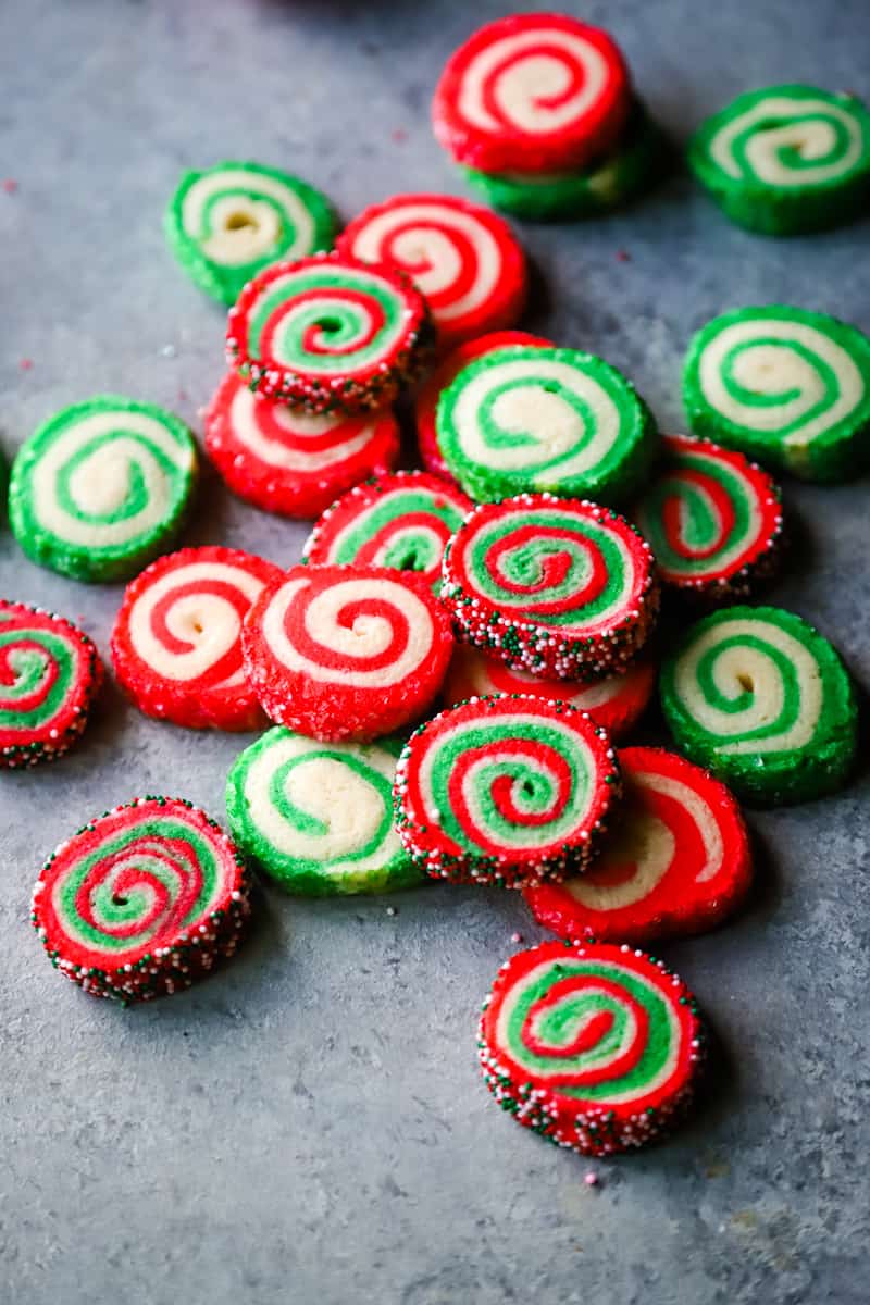 Red and green pinwheel Cookies laid out on a metal background. 